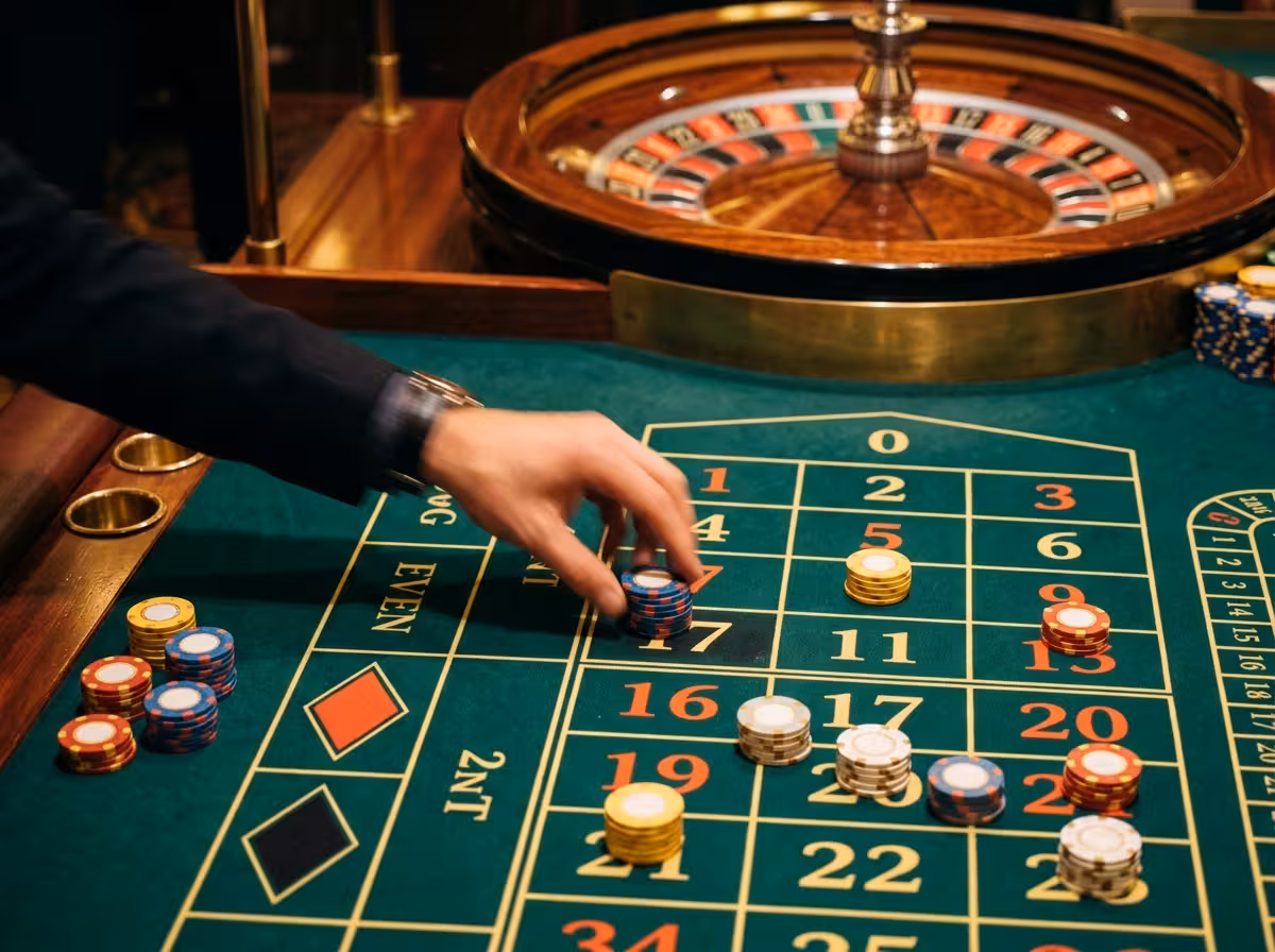 Détail de roulette de casino avec jetons et main floutée